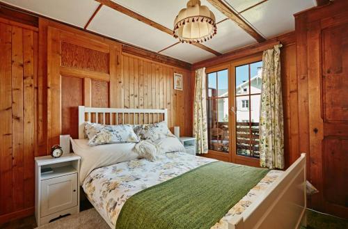 Schlafzimmer mit einem Bett und einem Kronleuchter in der Unterkunft Le Liseron in Leysin