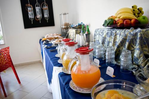 a blue table with a row of jars of orange juice at Hotel The Queen in Pastorano