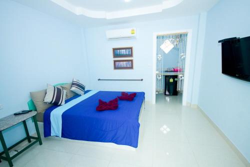 a bedroom with a blue bed with red pillows at HappyLove1 in Ko Larn