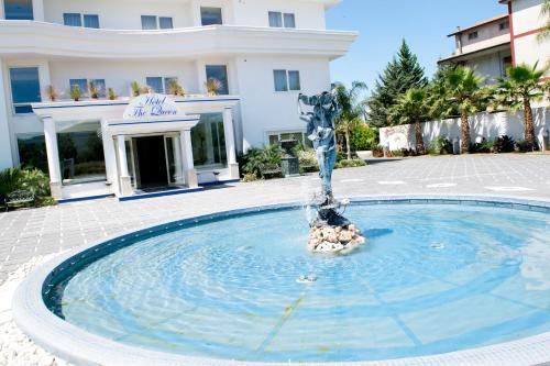 a fountain in a pool in front of a building at Hotel The Queen in Pastorano