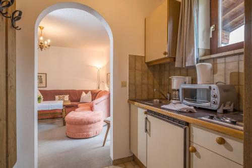 a kitchen with an archway leading to a living room at Das Landhaus am See in Achenkirch