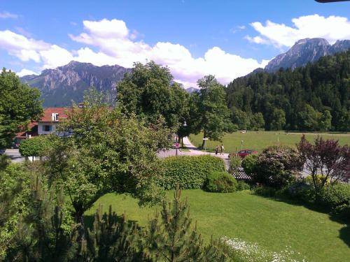 a view of a garden with mountains in the background at Hotel Kleiner König in Schwangau