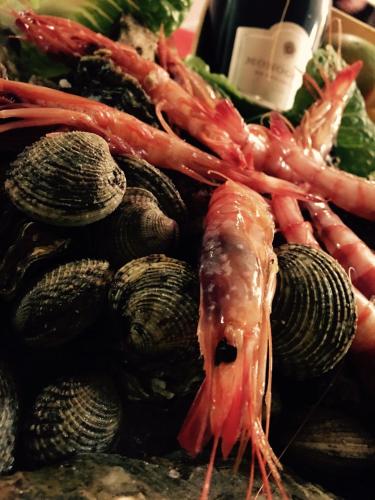 a pile of seafood and vegetables with a bottle of wine at Villa D'Anzi B&B in Ginosa