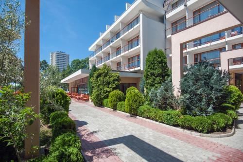 an apartment building with a courtyard with trees and bushes at Mercury Hotel-Premium All Inclusive in Sunny Beach