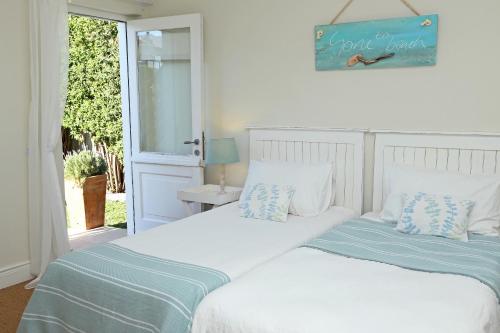 dos camas sentadas una al lado de la otra en un dormitorio en Shore's Edge Luxury Oceanfront Home, en Hermanus
