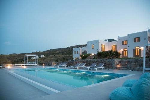 een zwembad met stoelen en gebouwen op de achtergrond bij Agiasi Villas in Lefkes