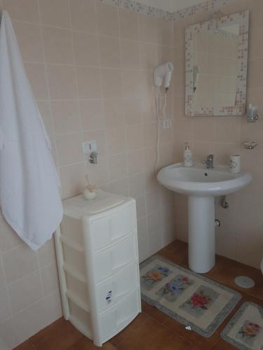 ein weißes Badezimmer mit einem Waschbecken und einem Spiegel in der Unterkunft Iris Appartamenti in Santa Maria La Carità