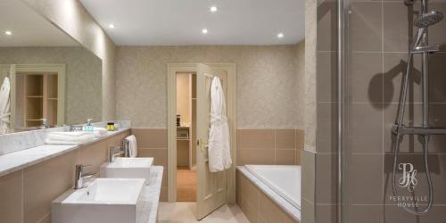 a bathroom with a sink and a tub and a shower at Perryville House in Kinsale