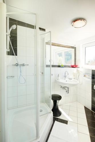 a bathroom with a shower and a sink at Hotel Kleiner König in Schwangau