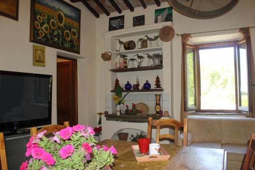 a living room with a table and a television at Casa Burraia in Abbadia di Montepulciano