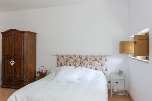 a bedroom with a white bed and a wooden cabinet at Il Borgo Di San Michele in Papigno