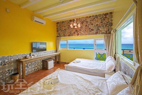 1 dormitorio con 2 camas y una ventana con vistas al océano en 180 Beach Front Villa en Magong