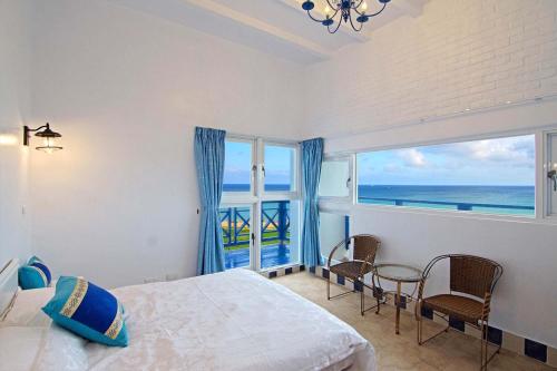 1 dormitorio con cama y vistas al océano en 180 Beach Front Villa en Magong