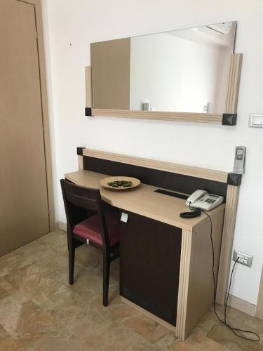 a desk in a room with a phone and a mirror at Rosso Di Sera in Citta' Sant'Angelo