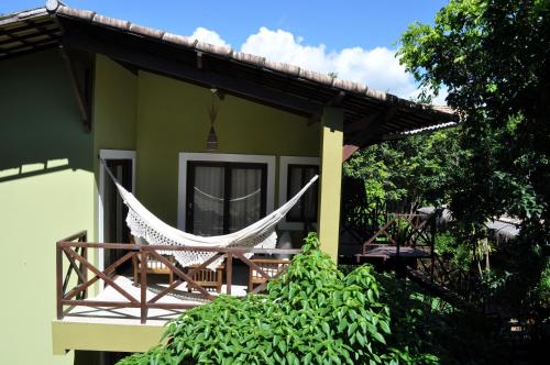 a hammock on the porch of a house at Recanto da Mata Pipa in Pipa