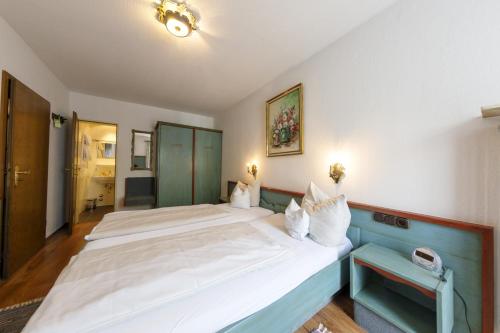 a bedroom with two large white beds in it at Hotel & Gasthof Fraundorfer in Garmisch-Partenkirchen