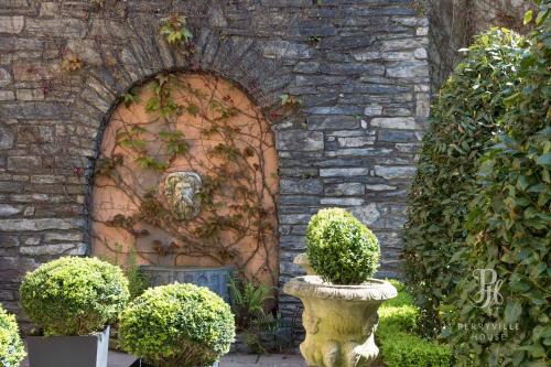 a stone building with a statue in front of a wall at Perryville House in Kinsale