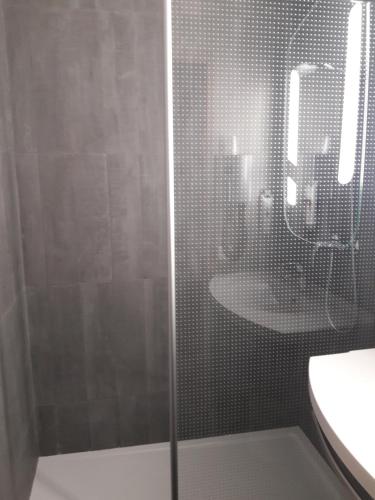 a bathroom with a shower with a sink and a mirror at ibis Vesoul in Vesoul