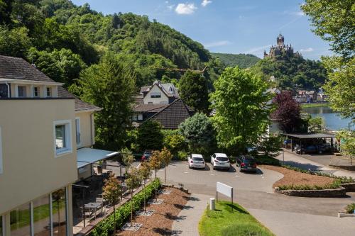 a house with trees and houses on the side of the road at Parkhotel Cochem in Cochem