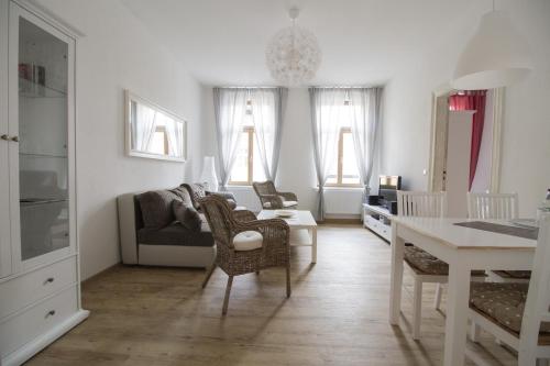 a white living room with a couch and a table at Ferienwohnungen EULE in Lutherstadt Wittenberg