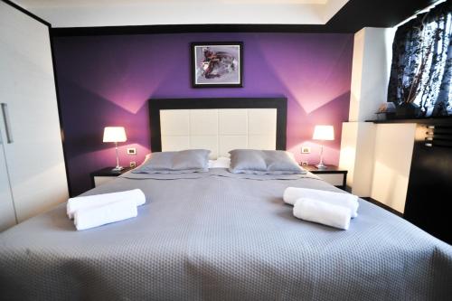 a bedroom with a large bed with purple walls at B&B Rose in Vranje