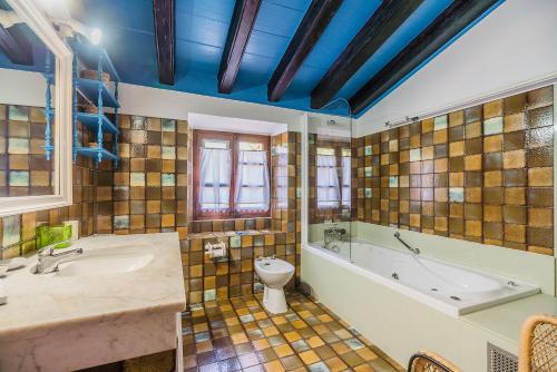 a bathroom with a tub and a toilet and a sink at Can Giro in Pollença