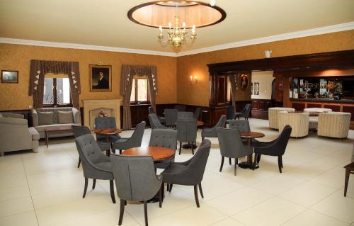 a restaurant with tables and chairs and a chandelier at Quorn Country Hotel Leicester in Loughborough