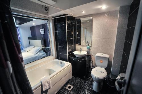 ヴラニェにあるB&B Roseのバスルーム(バスタブ、トイレ付)、ベッド1台が備わります。