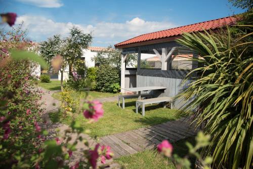 a garden with a bench and a gazebo at Motel Saint Georges d'Oléron in Saint-Georges-dʼOléron