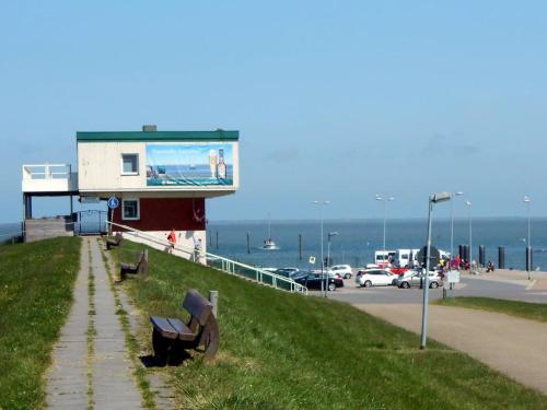 a building with a billboard on the side of a beach at FeWo Schwarz in Dornumersiel