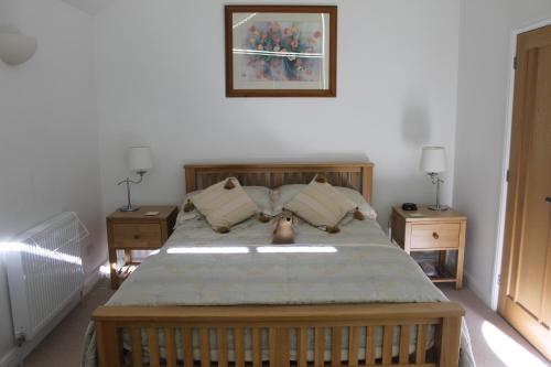 a bedroom with a large bed with two night stands at Pear Tree House Studio in Ely