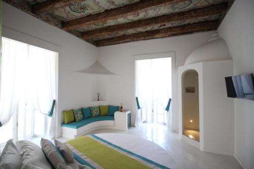 a white room with a bed and a couch at I Soffitti Dimora Esclusiva in Tropea