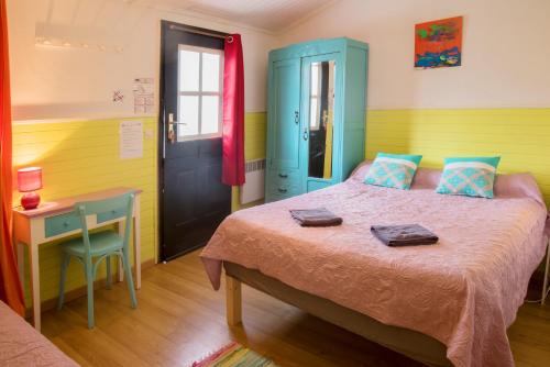 a bedroom with a bed and a desk and a door at Motel Saint Georges d'Oléron in Saint-Georges-dʼOléron