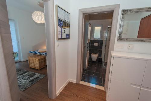 een hal die leidt naar een badkamer met een spiegel en een kamer bij ARENA Apartment 5-Stars Premium-Accommodation in Makarska