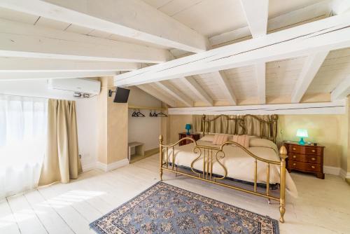 ロマーノ・ディ・ロンバルディーアにあるLe Residenze del Tenoreのベッドルーム1室(ベッド1台、ラグ付)