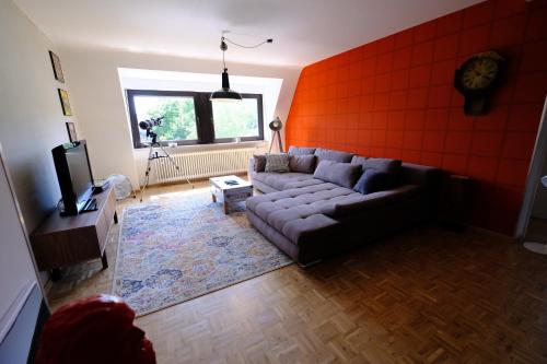 a living room with a couch and an orange wall at Domus Merian XII in Trier