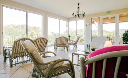 a room with chairs and tables and windows at Logis Hotel Restaurant La Porte des Cévennes in Anduze