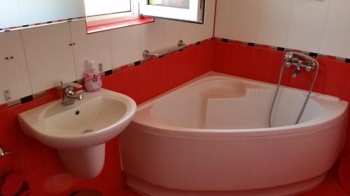 une salle de bain avec une baignoire et un lavabo dans l'établissement Къща за гости Йонкин Вършец, à Varshets