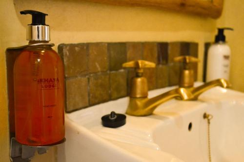 a bottle of soap sitting on top of a bathroom sink at iKhaya Lodge in Cape Town