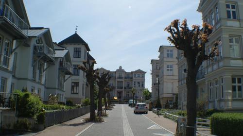 a street with buildings and a car driving down a street at Villa Pippingsburg am Strand in Ahlbeck