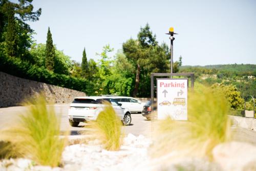 a parking sign with cars parked in a parking lot at Logis Hotel Restaurant La Porte des Cévennes in Anduze