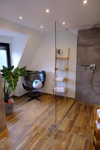 uma casa de banho com uma cabina de duche em vidro e uma banheira preta. em Domus Merian XII em Trier