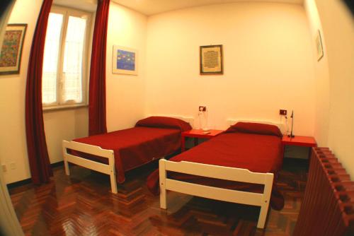 パレルモにあるAppartamento Politeamaのベッド2台と窓が備わる小さな客室です。