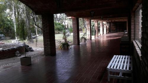 un pabellón con dos bancos en un suelo de ladrillo en Grand Hotel by MH en Termas de Río Hondo