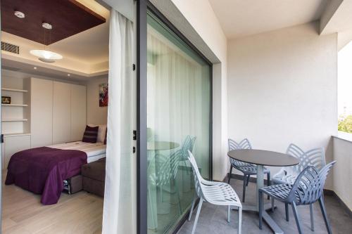 a balcony with a table and chairs and a bed at Mava Apartamente in Constanţa