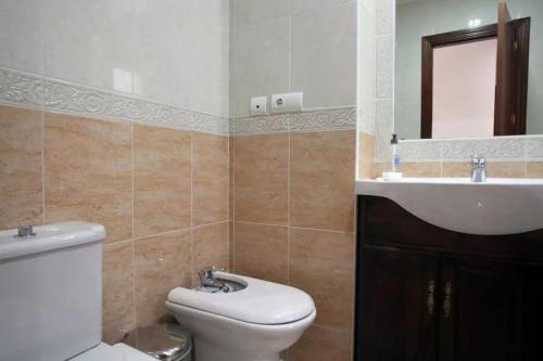 uma casa de banho com um WC branco e um lavatório. em Apartamento Atenea centro con garaje gratuito em Ronda