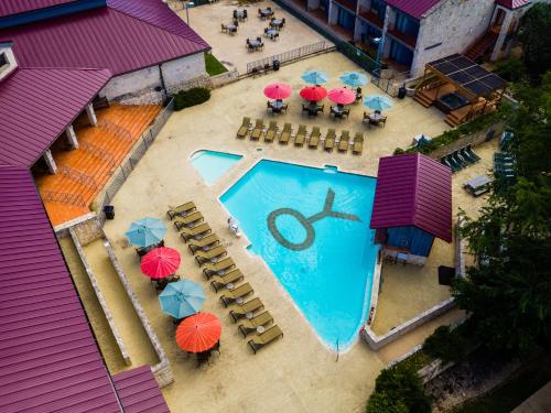an overhead view of a swimming pool with umbrellas and tables at Y O Ranch Hotel and Conference Center in Kerrville