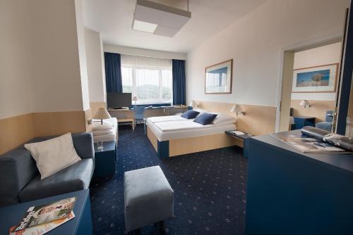 a hotel room with a bed and a couch at Hotel Grand Litava Beroun in Beroun