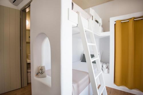a room with a white bunk bed with a ladder at Natura Villas Paros in Molos Parou