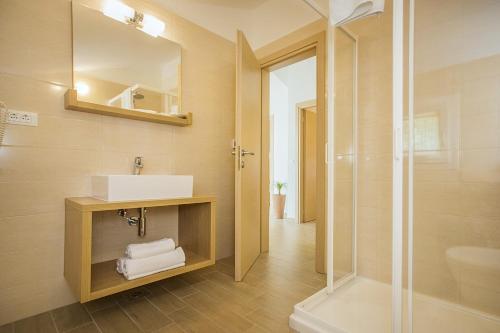 La salle de bains est pourvue d'un lavabo et d'une douche. dans l'établissement Residence Mediterraneo, à Baška